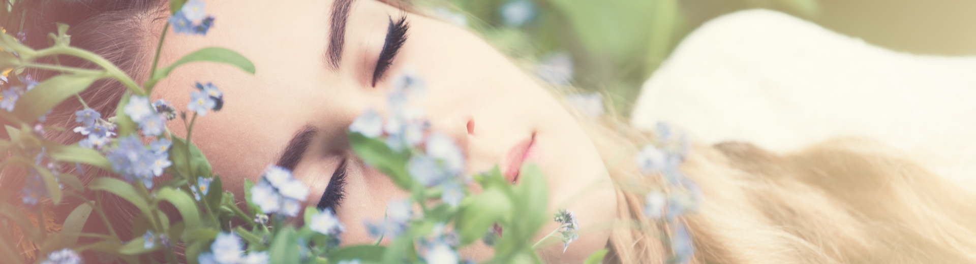 Porträt einer Frau zwischen zarten blauen Blüten, eine Aufnahme von Schulenburg Fotografie.